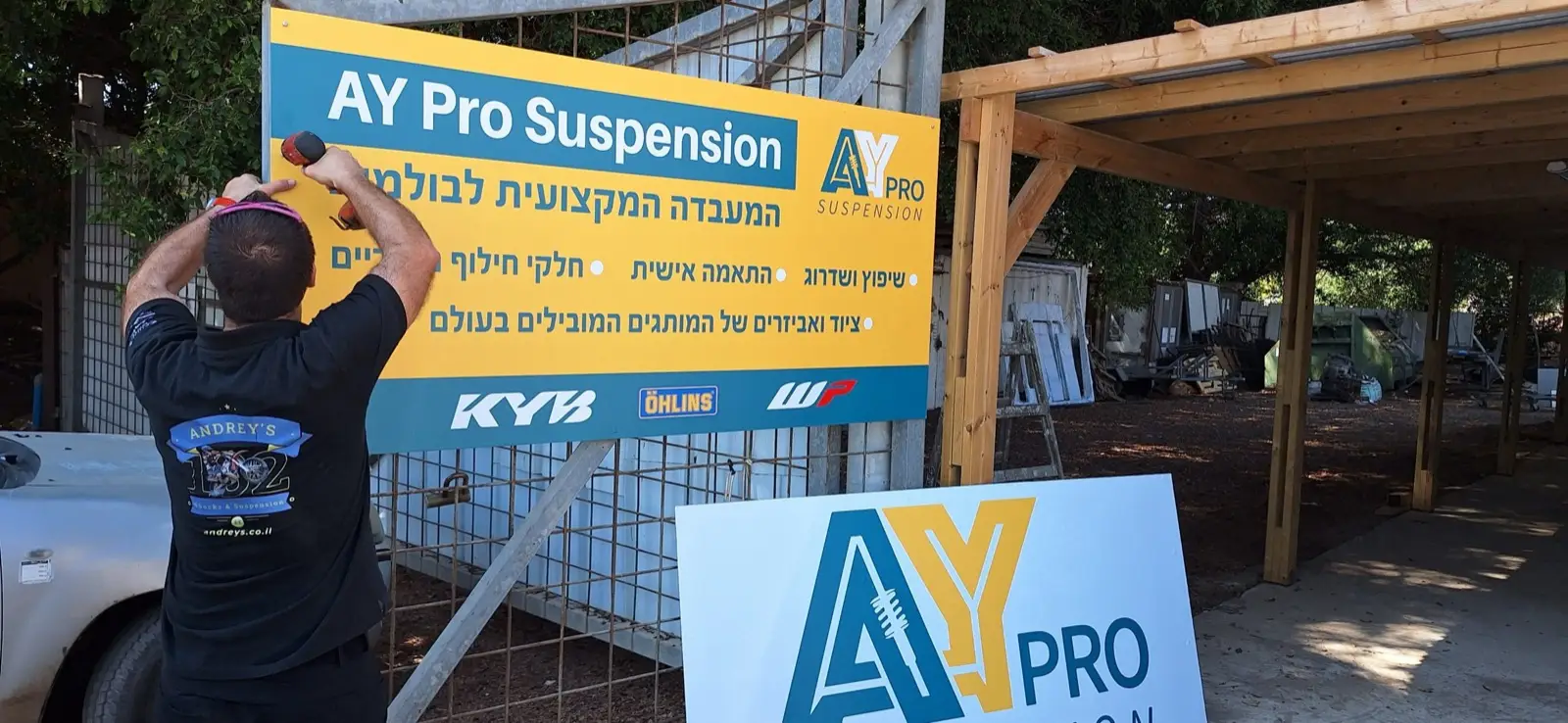 תליית שלט AY Pro Suspension בכניסה למעבדה